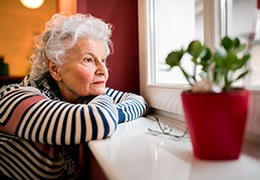 Sad older woman looking out the window