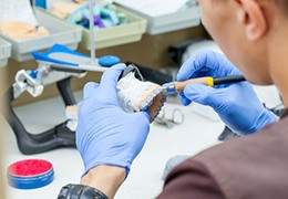 Dental lab technician working on dentures