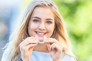 Patient holding clear aligners in hand