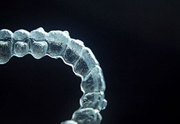 Close-up of clear orthodontic aligner against dark background