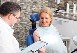 Dentist using clipboard to take notes during consultation