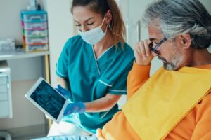 Dental team member and patient reviewing X-ray